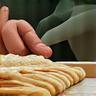 Icône illustrant des mains préparant de la pâtisserie, symbole du savoir-faire traditionnel